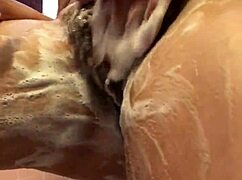 Drobná amatérka holí chlupatou kundičku v parní sprchové scéně.