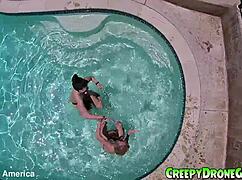 Lesbians are filmed by a drone in the outdoor pool for amateur video