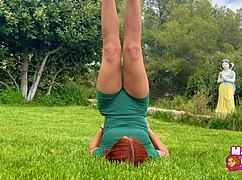 Redhead practices yoga outdoors in tight dress with stretching and flexibility