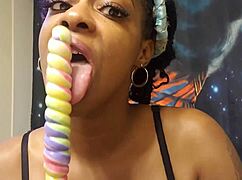 An ebony babe samples a unicorn lollipop with sucking.
