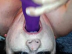 Ms. TL demonstrates throat techniques with toys and dildos in a messy setup