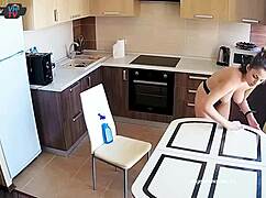 Big tits beauty cleans the kitchen topless, showing off pierced nipples.