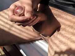 guy jerks his big cock in bed during summer