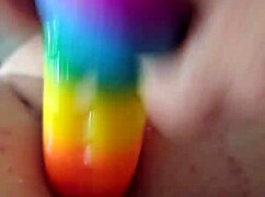 feeling the rainbow dildo slide into my ass, moaning with pleasure.