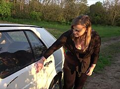 Stranded young babe bends over old car