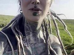 happy hippie chats cows while flashing tattooed body