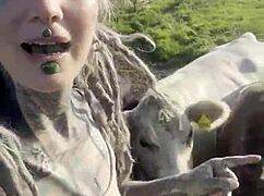 happy hippie chats cows while flashing tattooed body