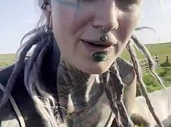 happy hippie chats cows while flashing tattooed body