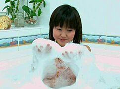 this cute skinny asian teen fingers her shaved pussy in the bath tub