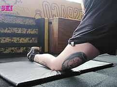 alternative tattooed girl stretches deep at gym