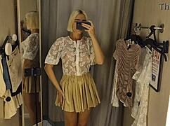 She flashes big tits through see-through clothes in mall changing room spy cam