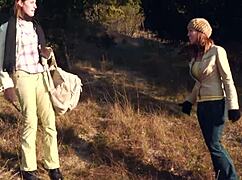 lesbian couple shares a soft kiss outdoors then straps on for heated pussy licking action