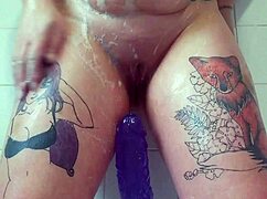 Masturbating wildly in the bath, my big purple dildo drives me to explosive cum