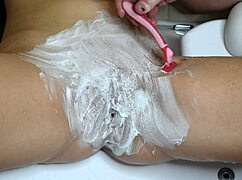 shaving her SUPER HAIRY PUSSY with trimmer razor and foam closeup