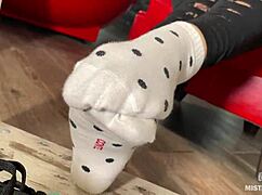 Goddess teases feet in socks under desk